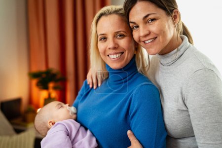 Photo for Happy lesbian couple with small baby at home portrait - LGBT family concept - Royalty Free Image