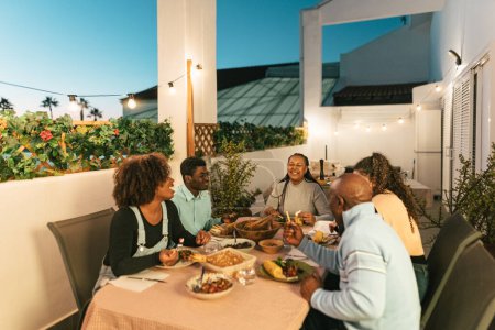 Téléchargez les photos : Happy African family dining together on house patio - en image libre de droit