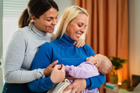 Photo for Happy lesbian couple having tender moments with their small baby at home - Family and maternity concept - Royalty Free Image