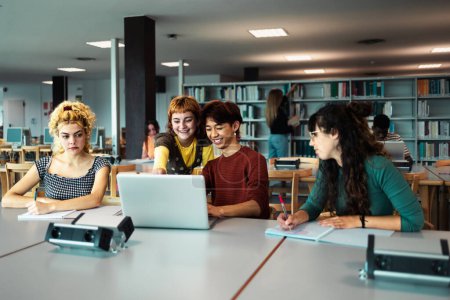 Foto de Jóvenes estudiantes universitarios usando laptop y estudiando con libros en la biblioteca - Concepto de educación escolar - Imagen libre de derechos