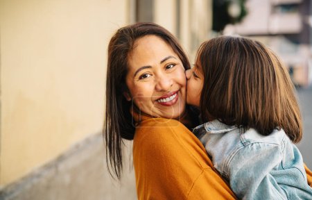 Glückliche philippinische Mutter mit ihrer Tochter mit zarten Momenten in der Innenstadt - Schöne Familie im Freien