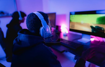 Foto de Jóvenes jugadores se divierten jugando videojuegos en línea con el ordenador en casa - Juego de entretenimiento y el concepto de tecnología - Imagen libre de derechos