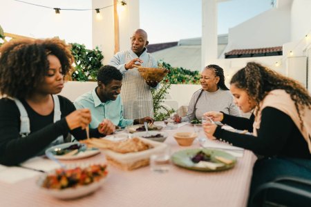 Téléchargez les photos : Happy African family dining together on house patio - concept de rencontres familiales - en image libre de droit