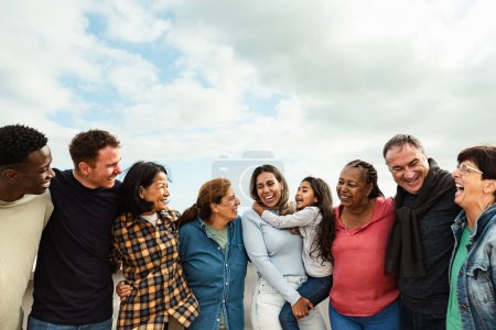 Téléchargez les photos : Heureux amis multigénérationnels avec différentes ethnies s'amuser sur le toit de la maison - Diversité style de vie des gens - en image libre de droit