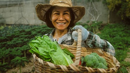 Foto de Feliz mujer del sudeste asiático trabajando dentro de la tierra agrícola - concepto de estilo de vida de los agricultores - Imagen libre de derechos
