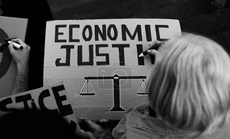 Foto de Activista principal preparando pancartas de protesta contra la crisis financiera - Concepto de activismo por la justicia económica - Edición en blanco y negro - Imagen libre de derechos
