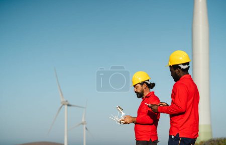 Téléchargez les photos : Drone engineers working on wind turbine farm - Alternative energy and aerial engineering concept - en image libre de droit