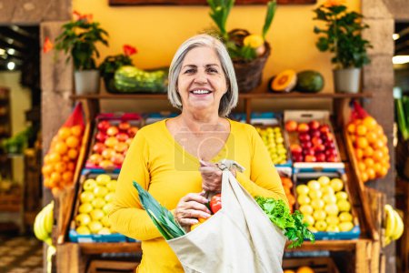 Foto de Mujer mayor feliz comprando frutas y verduras en el mercado - Concepto de compra de alimentos - Imagen libre de derechos