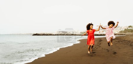 Téléchargez les photos : Heureux enfants africains s'amuser sur la plage pendant les vacances d'été - en image libre de droit