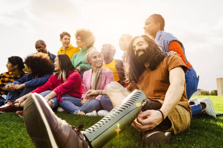 Téléchargez les photos : Multi ethnie s'amuser dans un parc public - Amputé homme traîne avec ses amis en plein air - Concept d'amitié et de diversité - en image libre de droit