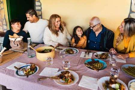 Foto de Feliz familia latina divirtiéndose almorzando juntos en casa - Imagen libre de derechos