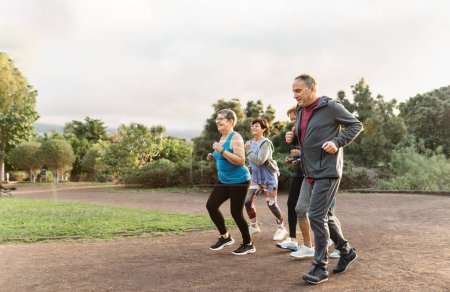 Foto de Grupo de personas mayores diversas corriendo juntas en el parque - Imagen libre de derechos