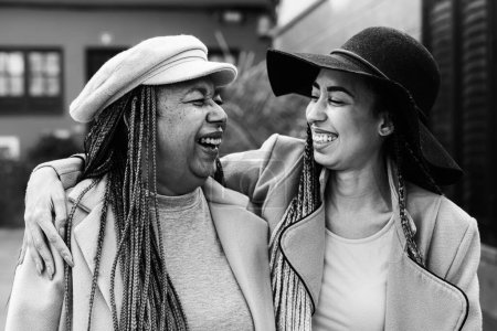 Foto de Madre e hija africana feliz caminando al aire libre - Concepto de estilo de vida familiar encantador - Edición en blanco y negro - Imagen libre de derechos