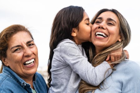 Glückliche hispanische Familie genießt gemeinsame Zeit - Kind vergnügt sich mit Mutter und Großmutter im Freien