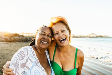 Photo for Happy senior multiracial women having fun on the beach during summer holidays - Diverse elderly friends enjoying vacations - Royalty Free Image