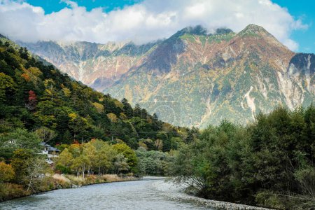 Téléchargez les photos : Bel arrière-plan du centre du parc national de Kamikochi par des montagnes de neige, des rochers et des rivières Azusa des collines couvertes de feuilles changent de couleur pendant la saison des feuillages d'automne. - en image libre de droit