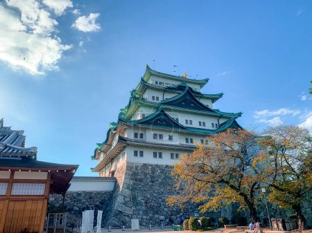 Foto de Film grain Nagoya, Japón Octubre 2022 Castillo de Nagoya con un cielo despejado durante el aderezo de hojas de otoño. Castillo de Nagoya es un punto de referencia en el centro de Chubu de Japón y tiene samurai como el símbolo del castillo. - Imagen libre de derechos