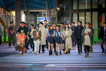 Photo for Sapporo, Japan - October 2023: Halloween night with a crowd of Japanese teenagers wearing Halloween costumes and makeup walking the footpath in the Susukino cross area. - Royalty Free Image