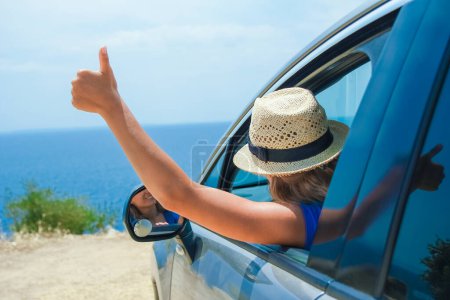 glückliches Mädchen aus dem Auto auf See Griechenland Hintergrund