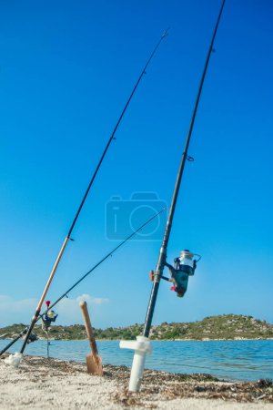 Photo for Fishing rods of a happy fisherman near the sea in nature on a journey background - Royalty Free Image