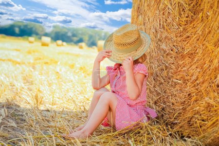 Photo for Happy child on a field with bales harvest in autumn - Royalty Free Image