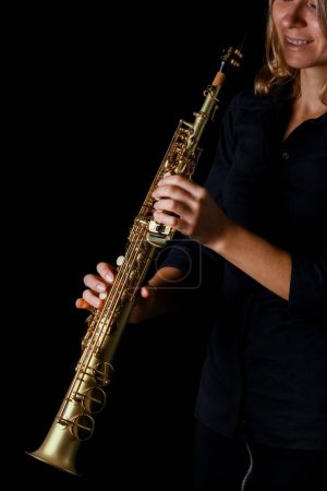 Foto de Saxofón soprano en manos sobre fondo negro - Imagen libre de derechos