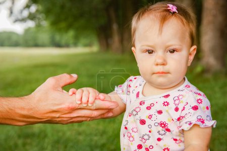 Téléchargez les photos : Mains d'un parent heureux et d'un enfant dans la nature - en image libre de droit