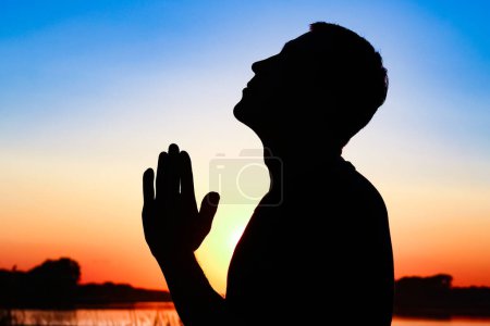 Photo for Silhouette of man praying at sunset background - Royalty Free Image