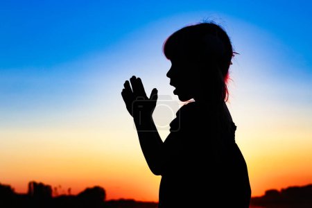 Foto de Silhouette of man praying at sunset background - Imagen libre de derechos