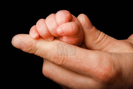 Photo for Beautiful baby lies on the hands of the parent handles legs background - Royalty Free Image