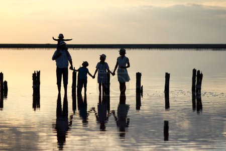 Photo for Happy family silhouette at sea with reflection in park in nature - Royalty Free Image