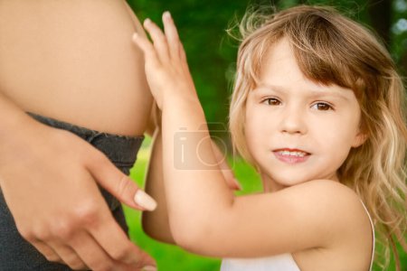 Photo for Happy pregnant woman with a child on the nature in the park - Royalty Free Image