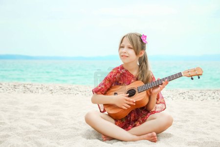 Photo for Happy child playing guitar by the sea greece on nature background - Royalty Free Image