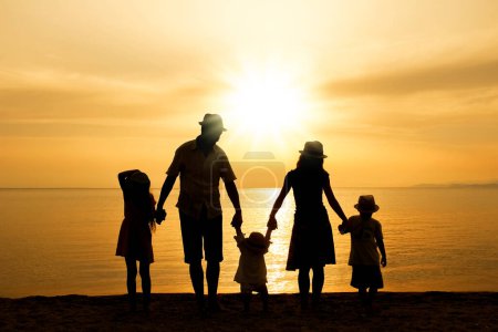 Foto de Familia feliz en la naturaleza junto al mar en una silueta de viaje - Imagen libre de derechos