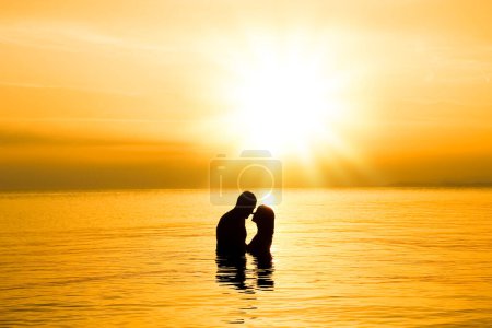 Téléchargez les photos : Couple heureux dans la mer sur la silhouette Voyage nature - en image libre de droit