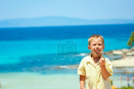 Foto de Niño feliz con helado junto al mar en la naturaleza en el viaje al parque - Imagen libre de derechos