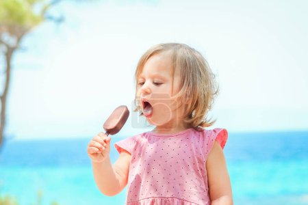 Photo for Happy child girl with ice cream by the sea in nature in the park journey - Royalty Free Image