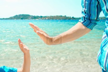 Foto de Manos de un padre feliz y un niño en la naturaleza junto al mar en un fondo de viaje - Imagen libre de derechos