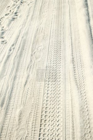 Téléchargez les photos : Traces d'une voiture dans le sable près de la mer en arrière-plan nature - en image libre de droit