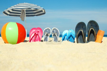 Photo for Beach summer holiday banner background. Flip-flops and hat with a board and ball on the sand near the ocean. Summer accessories on the seashore. Tropical vacation and relax travel concept. Top view and copy space. - Royalty Free Image