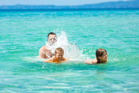 Téléchargez les photos : Famille heureuse jouant dans la mer dans la nature week-end Voyage - en image libre de droit