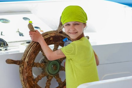 Photo for Happy child at the helm of the ship in the sea background - Royalty Free Image