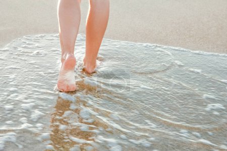 Téléchargez les photos : Élégantes belles jambes avec des traces de la mer en été sur la nature - en image libre de droit