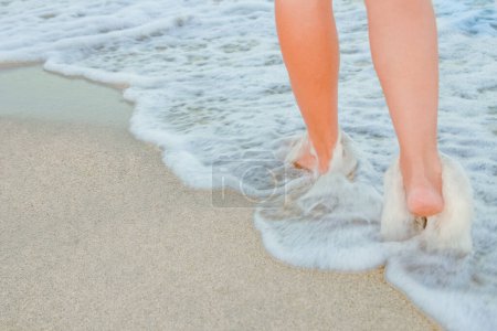 Téléchargez les photos : Élégantes belles jambes avec des traces de la mer en été sur la nature - en image libre de droit
