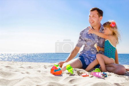 Photo for Happy parent dad playing on the sea with the child on the nature of the summer - Royalty Free Image