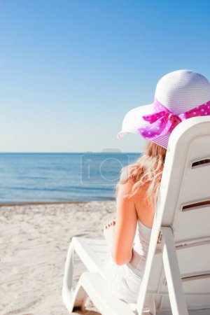 Téléchargez les photos : Heureuse fille dans une chaise longue sur la mer en été sur la nature - en image libre de droit
