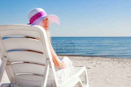 Photo for Happy girl in a chaise lounge on the sea in the summer on the nature - Royalty Free Image