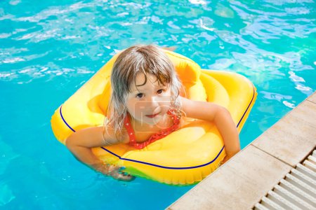 Téléchargez les photos : Enfant heureux sur la plage près de la piscine en plein air dans le parc d'été - en image libre de droit