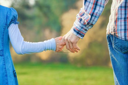 Téléchargez les photos : Belles mains de parents et d'enfants à l'extérieur dans le parc - en image libre de droit