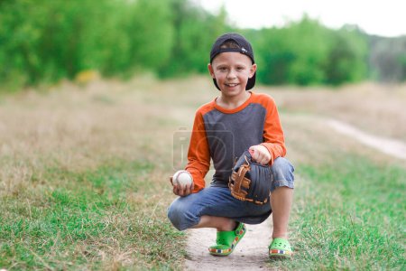 Foto de Niño feliz con pelota de béisbol en concepto de naturaleza en el parque - Imagen libre de derechos